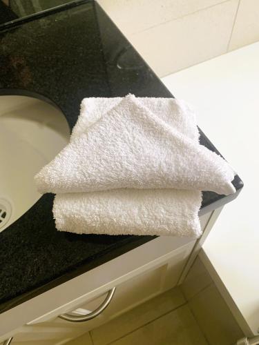 a pile of white towels sitting on a counter at Belton Apartments-Hedge Cottage in Hobart
