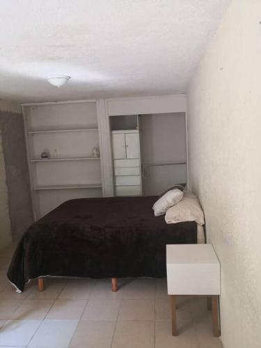 um pequeno quarto com uma cama e uma mesa em Loft E Metro Copilco UNAM Coyoacan- E em Cidade do México