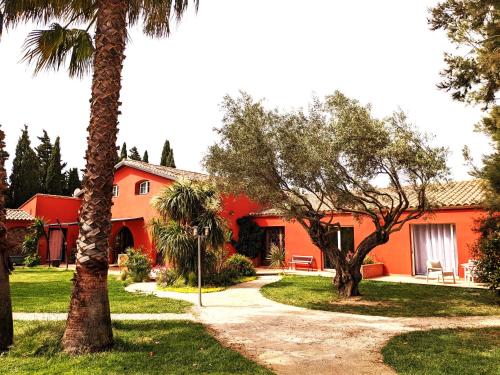 une maison orange avec des palmiers devant elle dans l'établissement Gite L olivier, à Baho