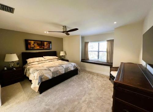 オーランドにあるStunning Ventura Condoのベッドと天井扇風機のある寝室