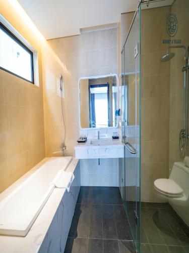 a bathroom with a tub and a sink and a shower at Chuỗi Villa 7 Ngủ Beverly Hill - Bãi Cháy - Bể bơi vô cục in Ha Long