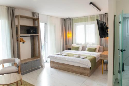 sypialnia z łóżkiem i telewizorem w obiekcie Olive Boutique Hotel w Limenárii