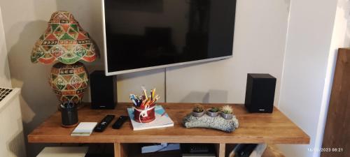 a table with a television and a desk with pens and pencils at Appartement meublé classé 3 étoiles de 72 m2, 2 chambres in Morzine