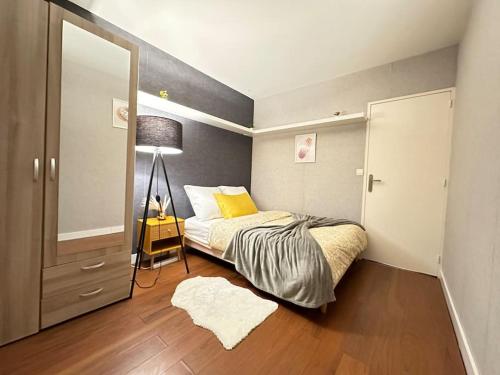 Exotic Spacious Stylish Apartment Retreat في Ris-Orangis: غرفة نوم بسرير ومخدة صفراء