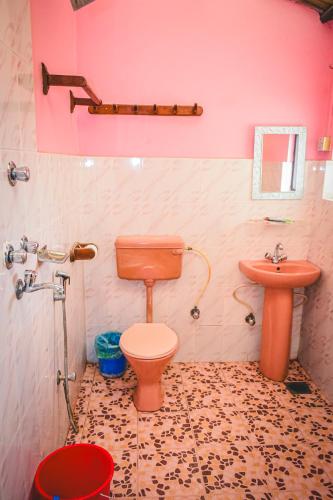 a bathroom with a toilet and a sink at Hotel Riverside with Swimming pool in Sauraha