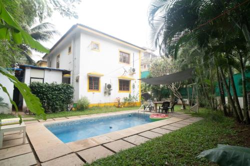 a house and a swimming pool in front of a house at Ronne's Casa De Piscina Privada 3BHK VILLA in Verla
