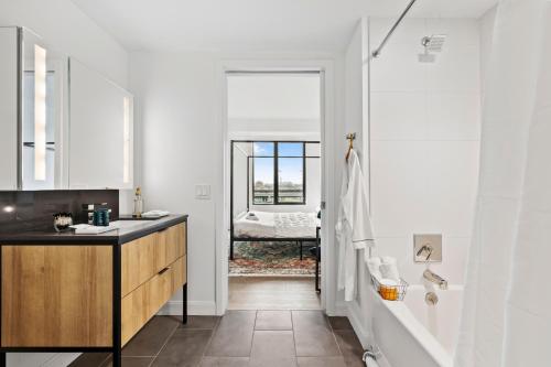 uma casa de banho branca com um lavatório e um espelho em Boston Cambridge Suites Family Edition by Orchard em Cambridge