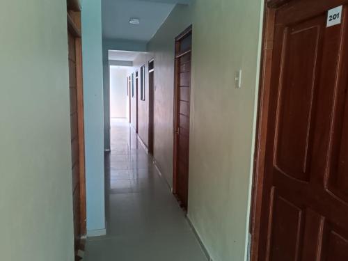 un couloir vide avec une rangée de portes et un hallwayngthngthngthngthngth dans l'établissement El tío Mero, à Tingo María