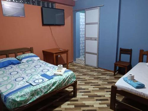 - une chambre avec 2 lits et une télévision à écran plat dans l'établissement El tío Mero, à Tingo María