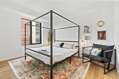 a bedroom with a canopy bed and a chair at Boston Cambridge Suites Family Edition by Orchard in Cambridge