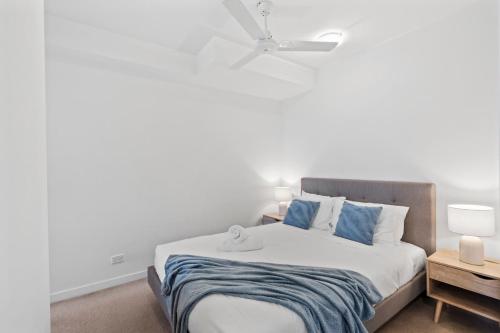 a bedroom with a large bed with blue pillows at Cozy 1 bedroom in the Heart of South Brisbane with parking in Brisbane