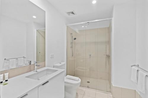 a white bathroom with a toilet and a shower at Cozy 1 bedroom in the Heart of South Brisbane with parking in Brisbane