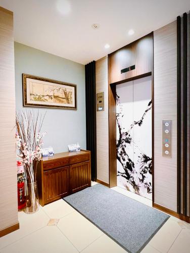 a hallway with a wooden door and a glass door at Hotel Arashi Namba No002 in Osaka