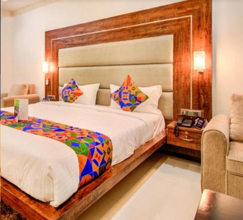 um quarto com uma cama grande e um sofá em Hotel Coral em Indore