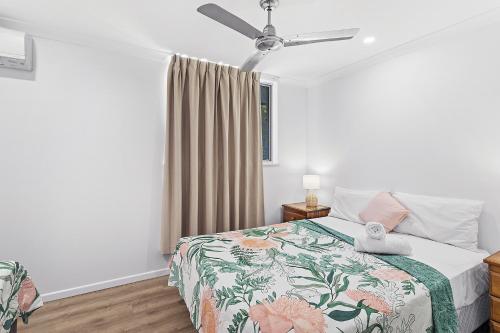 a bedroom with a bed and a ceiling fan at Unit 1 Sunbird on Lamond in Airlie Beach