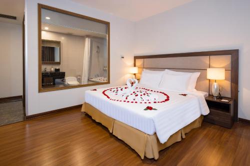 a bedroom with a large bed with a large mirror at Daphovina Hotel in Nha Trang