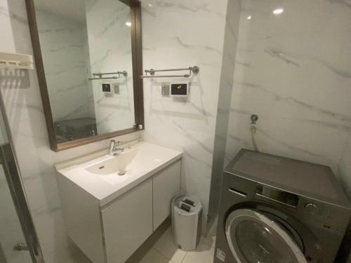 La salle de bains est pourvue d'un lavabo et d'un lave-linge. dans l'établissement Hangzhou inn Time Youth Hostel, à Hangzhou