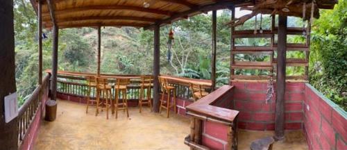 a pavilion with a table and chairs in a forest at Hotel El Santuario in Minca
