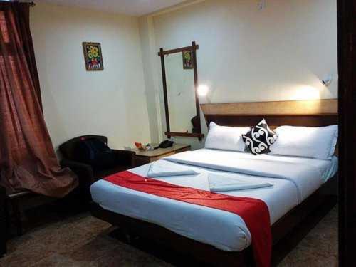 a bedroom with a large bed with a red blanket at OYO Hotel Nico in Port Blair