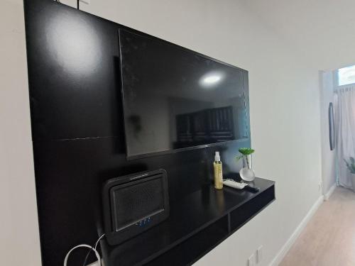 un televisor en una pared negra en una habitación en Lindo FLAT47 metrô e VLT da CARIOCA - LAPA, en Río de Janeiro