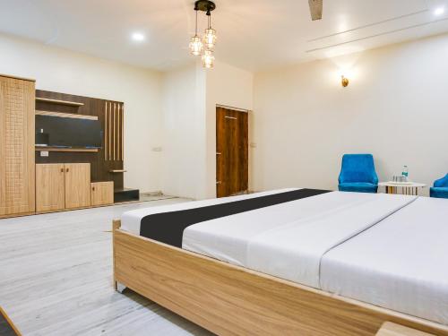 盧迪亞納的住宿－OYO Hotel Blue 7，一间卧室配有一张大床和两张蓝色椅子