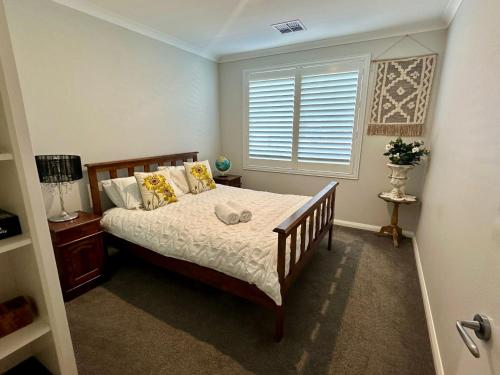 a bedroom with a bed and a window at Serenity by the Sea in Busselton