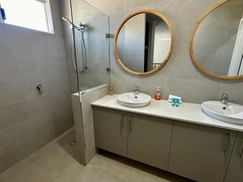 a bathroom with two sinks and a mirror at Serenity by the Sea in Busselton