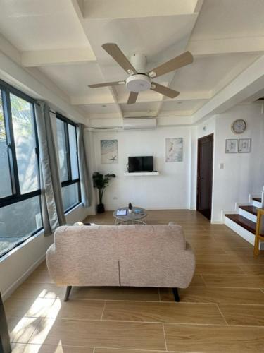 a living room with a couch and a ceiling fan at ZenStay Retreats Private Luxury Beach House Rental in Pandan