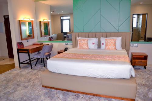 達累斯薩拉姆的住宿－KingJada Hotels And Apartments Ltd，一间卧室配有一张床、一张书桌和一张书桌