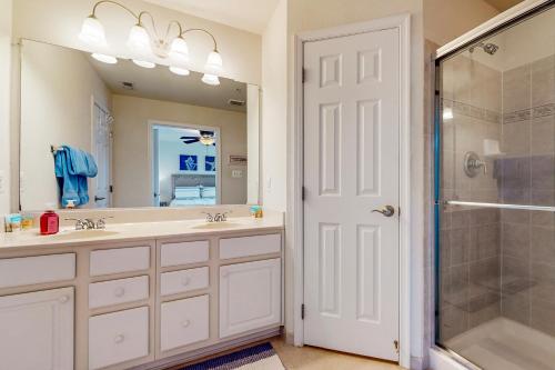 a bathroom with two sinks and a shower at Villas of Beach Cove --- 29076 Beach Cove Square #D7 in Bayberry Dunes