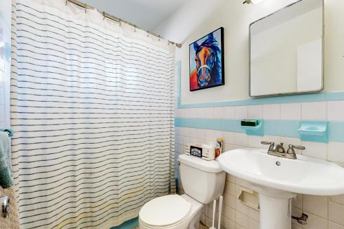 uma casa de banho com um WC branco e um lavatório. em The Peaceful Ocala Bungalow em Ocala