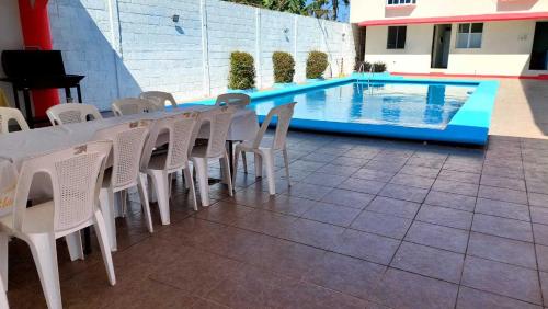 alberca Blass في كواتزاكوالكوس: طاولة وكراسي بجانب مسبح