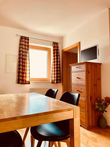 a dining room with a wooden table and chairs at Sonnenblumenhof in Mühlheim