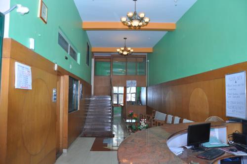 a large room with a table and a staircase at Vinayaka Deluxe Lodge in Kushālnagar