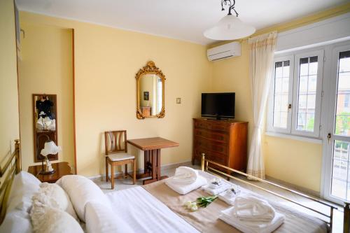 1 dormitorio con cama, mesa y espejo en Relaxing House en Lido di Ostia