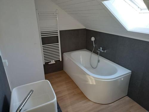 a bathroom with a white tub in a room at Welcoming holiday home by the sea in Godern