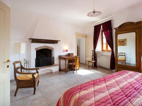 1 dormitorio con cama, escritorio y chimenea en Barbera at Villa Pesce, en Mombaruzzo