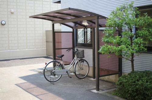 uma bicicleta estacionada sob um dossel ao lado de um edifício em Isesaki Station Hotel em Isesaki