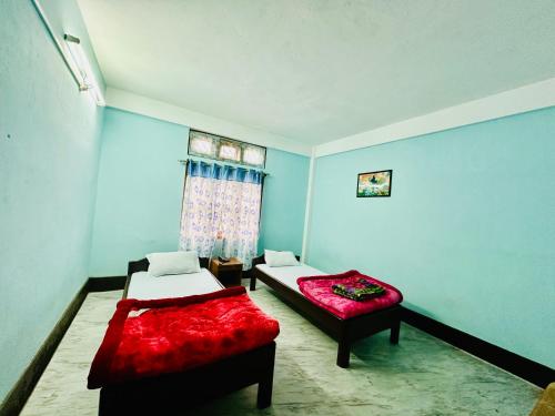 a bedroom with two beds and a window at Pema Dekey monastic guest house in Dirang Dzong