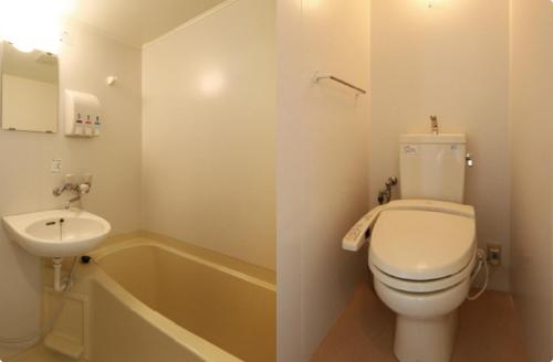 a bathroom with a toilet and a sink and a tub at Isesaki Station Hotel in Isesaki