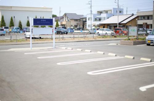 an empty parking lot with a sign on the street at Isesaki Station Hotel in Isesaki