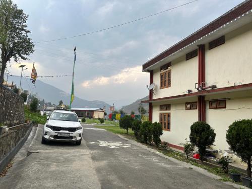 a car parked on a street next to a house at Pema Dekey monastic guest house in Dirang Dzong