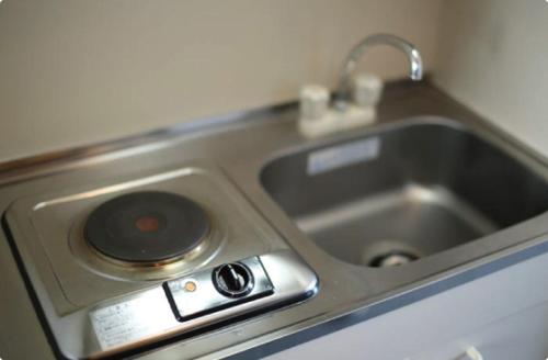 a kitchen counter with a sink and aaucet at Isesaki Station Hotel in Isesaki