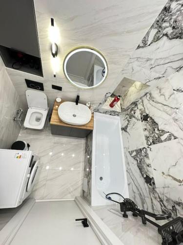 La salle de bains blanche est pourvue d'un lavabo et d'un miroir. dans l'établissement ЖК2 Estet147, à Almaty