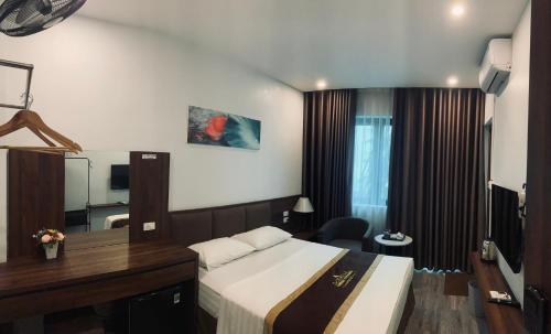 ein Hotelzimmer mit einem Bett und einem Schreibtisch in der Unterkunft Minh Thanh Homes - Hà Đông,Hà Nội in Hà Ðông
