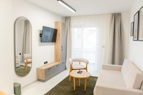 un soggiorno con divano bianco e specchio di Olive Boutique Hotel a Limenaria
