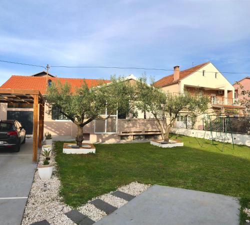 a yard with two trees and a house at Villa Enthia in Zadar