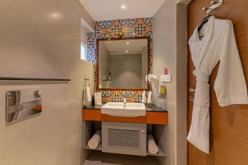 a bathroom with a sink and a mirror at Sterling Kodai Valley in Kodaikānāl