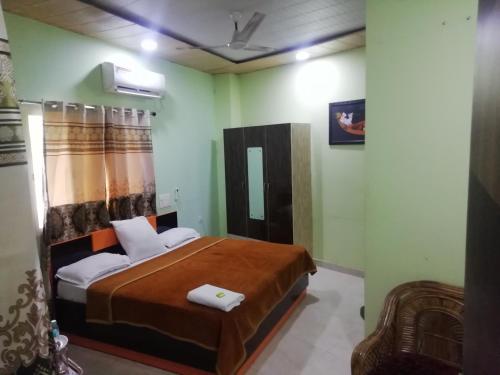 a bedroom with a bed and a chair at Radhe Radhe Guest House in Dehradun
