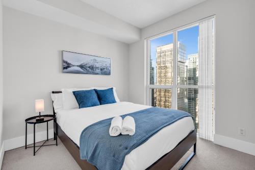 a bedroom with a bed and a large window at Executive Downtown Condo. MTCC, CN Tower in Toronto